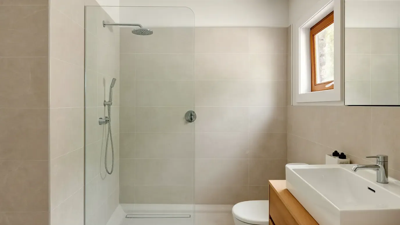 Base de duche sem degrau e móvel de carvalho numa casa de banho remodelada